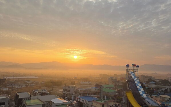 A cityscape with a water slide at sunset.