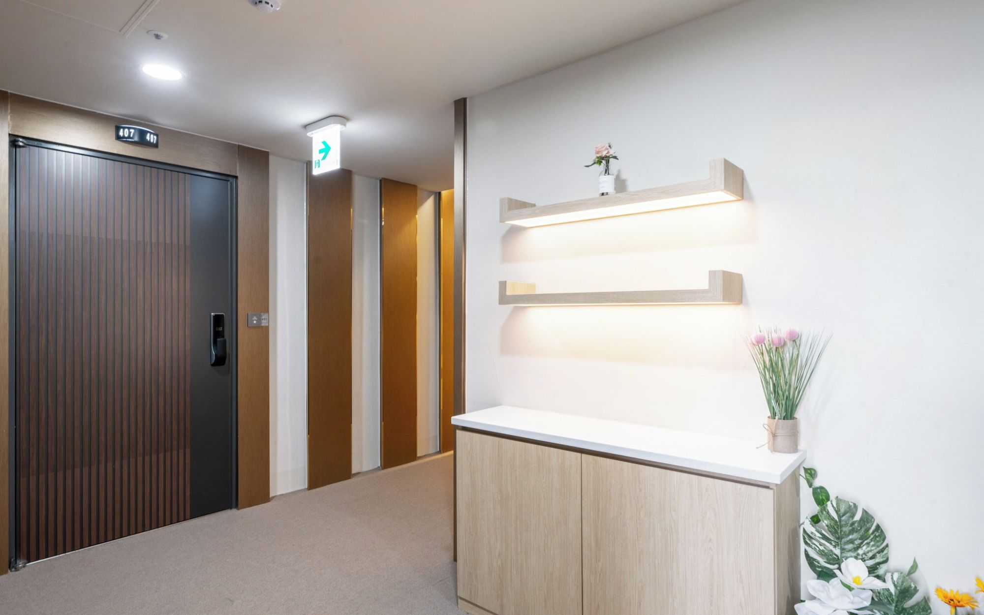 Ein Hotel-Empfangsbereich mit einer Rezeption, einer Holztür und einer Wandleuchte.