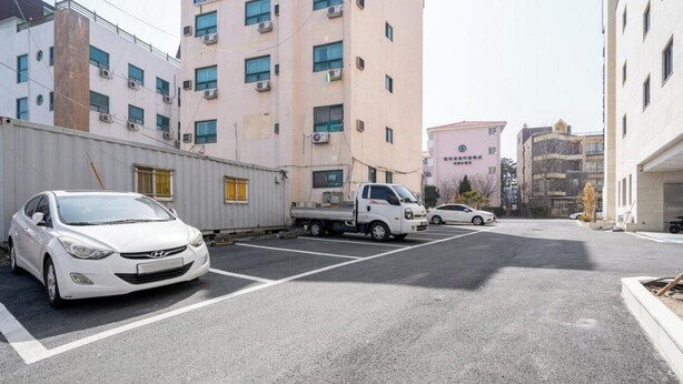 Un parcheggio con un'auto bianca e un camion bianco.