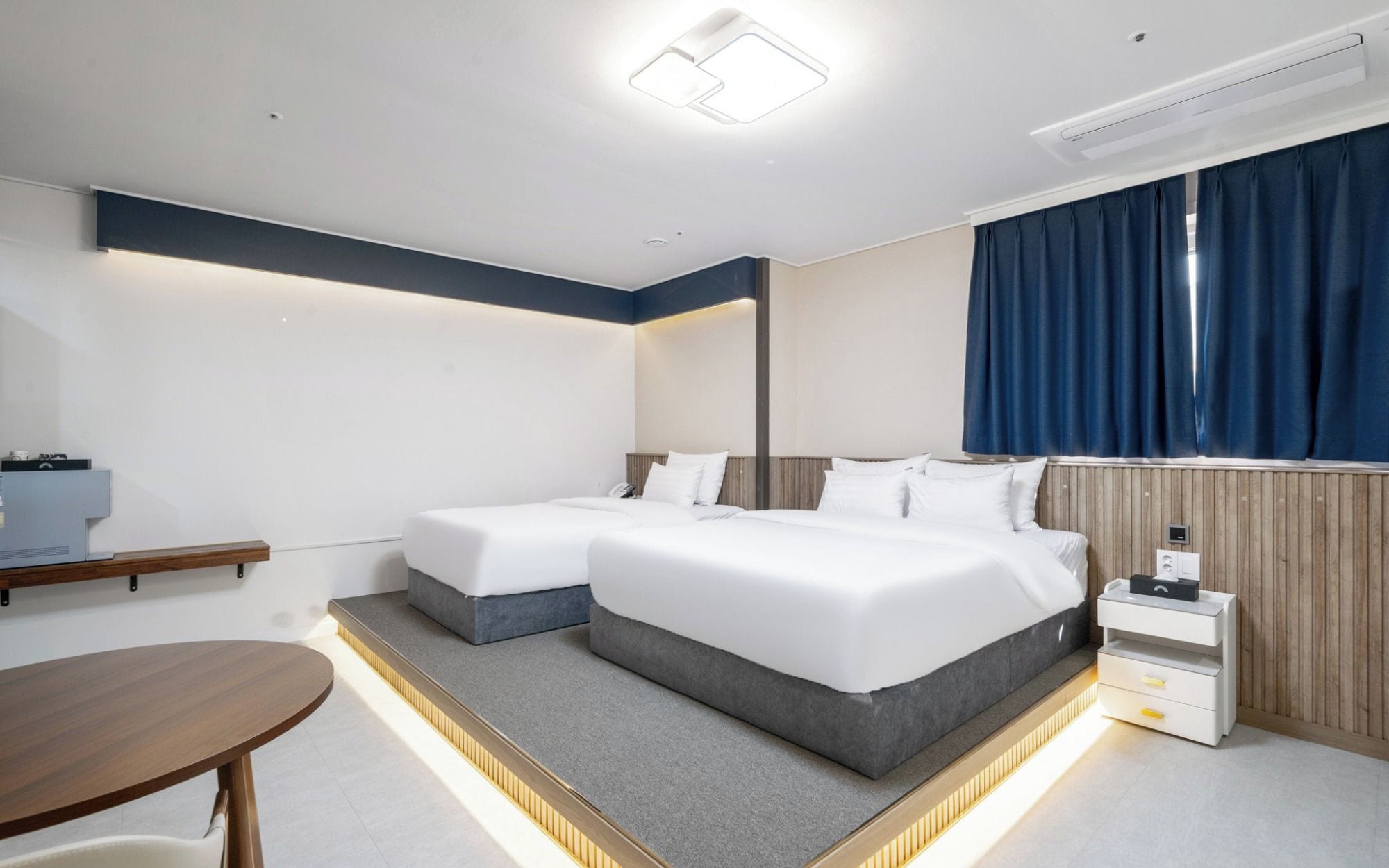 A hotel room with a bed, bedside tables, a desk, and a chair.