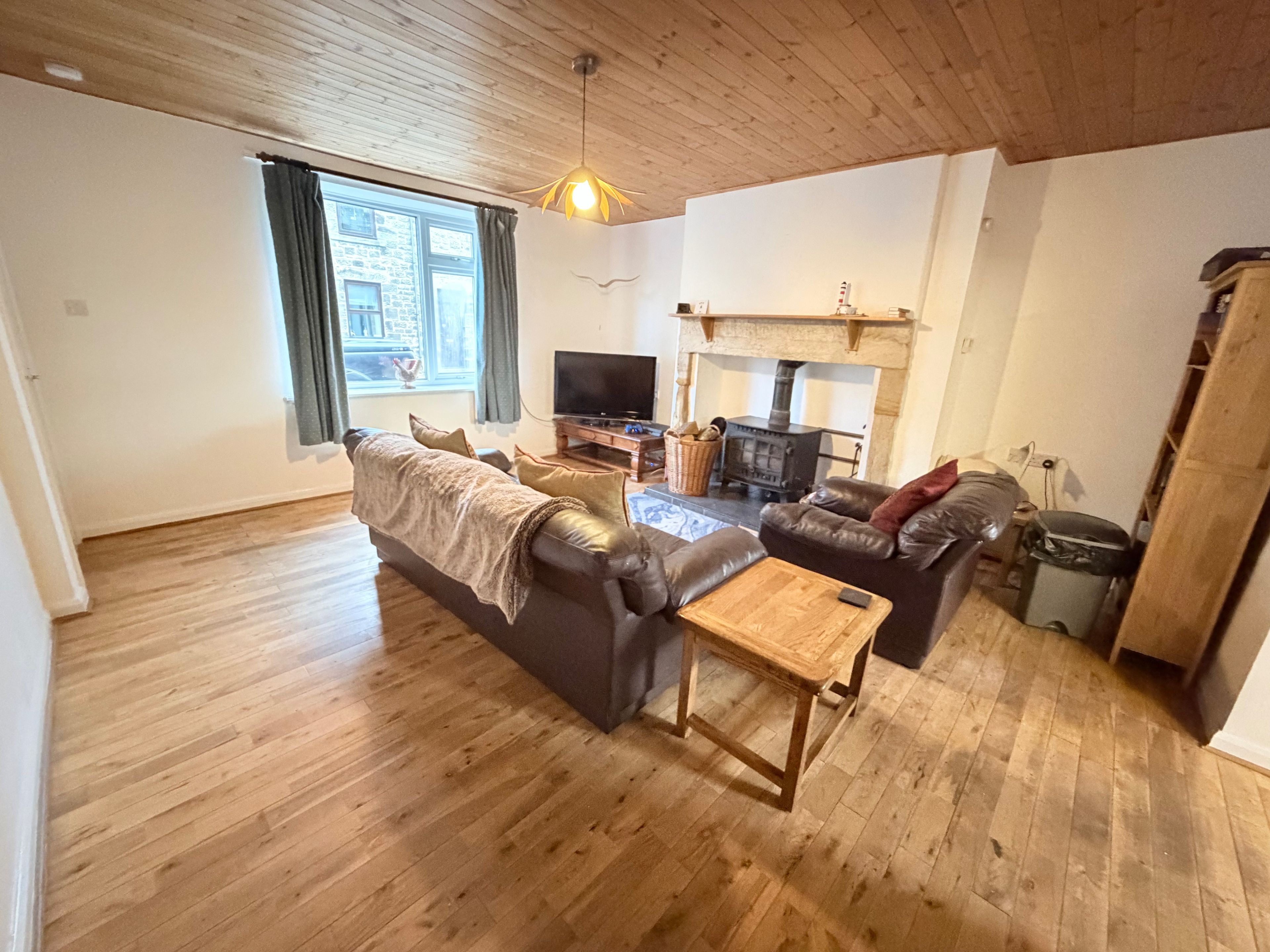 A living room with a sofa, a coffee table, a television, and a fireplace.