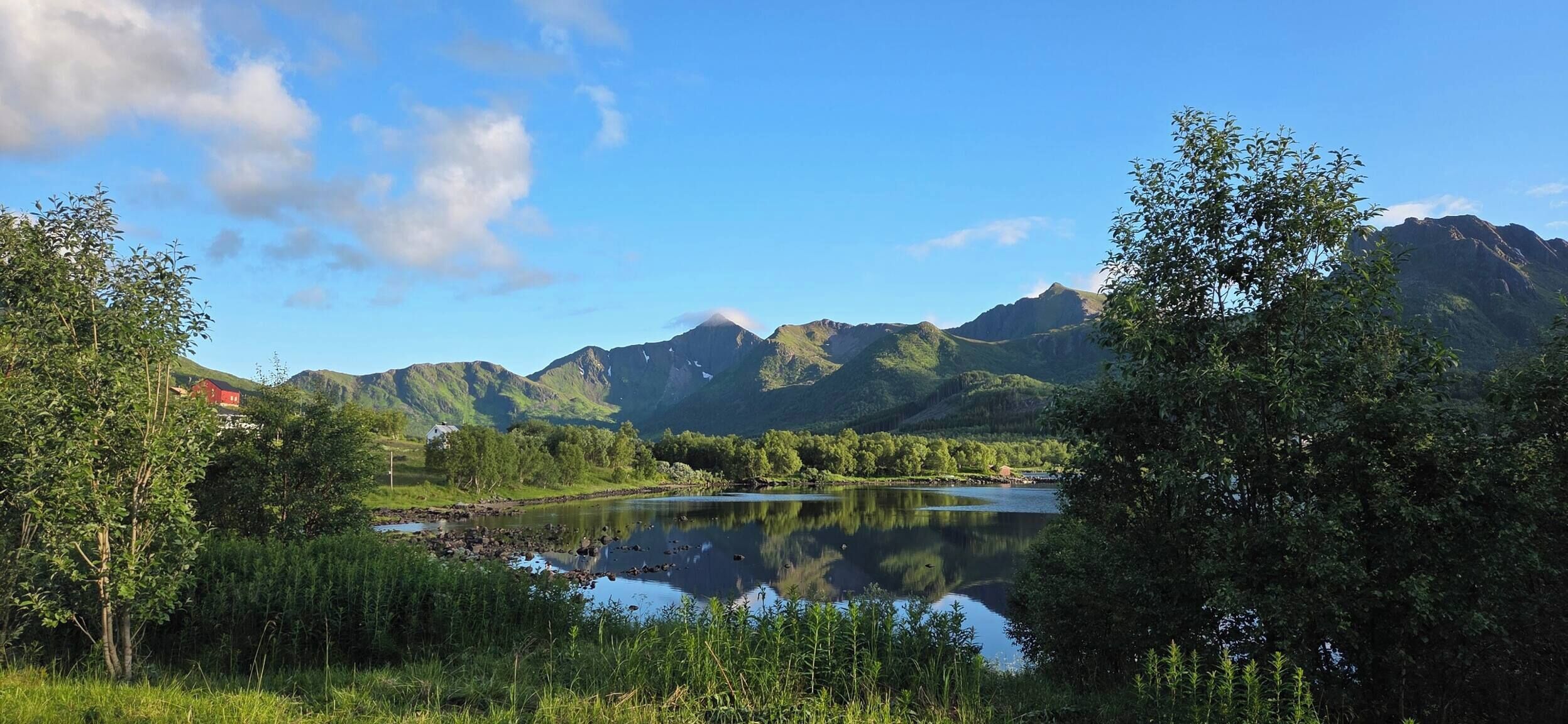 En sjö omgiven av berg och träd.
