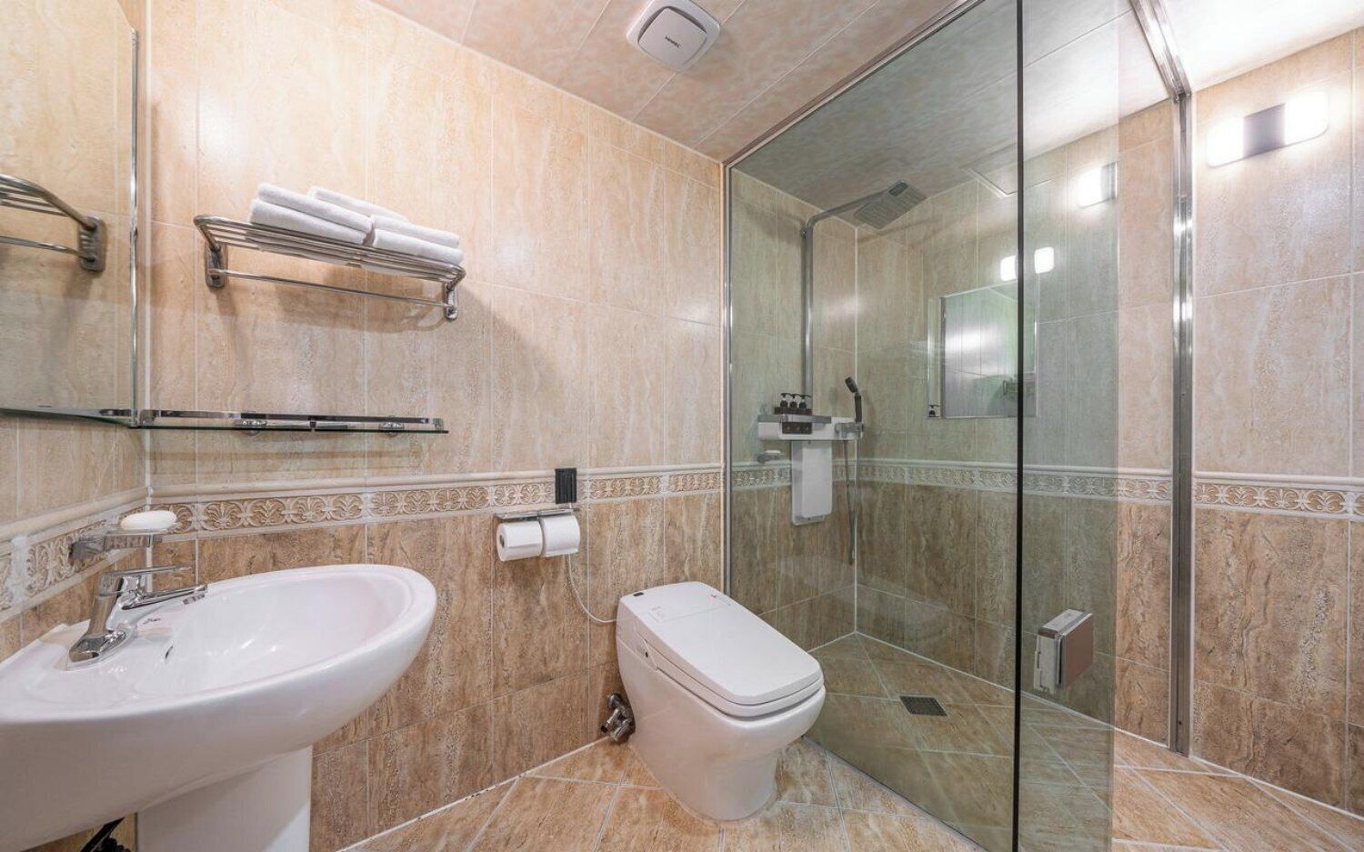 A modern bathroom with a glass shower enclosure, a sink, and a toilet.