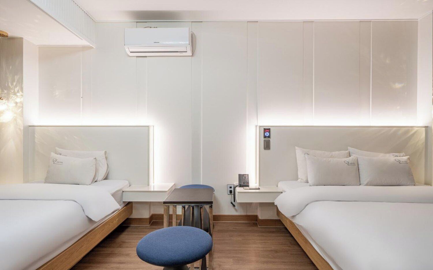 Une chambre d’hôtel avec deux lits, un bureau et un appareil de climatisation.