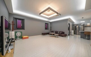 A spacious living area with a sectional sofa, a coffee table, and a built-in kitchen unit.