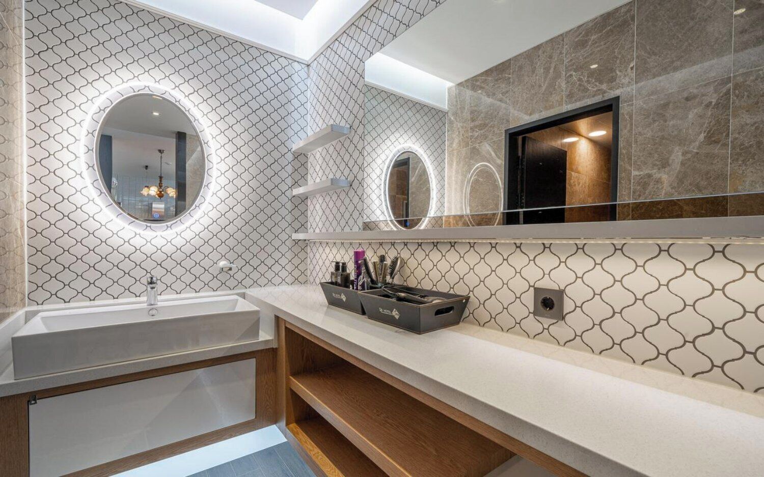 Une salle de bain moderne dotée d’un grand miroir, d’un lavabo encastré et d’un meuble-lavabo avec espace de rangement.
