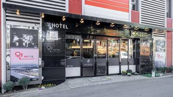 Un hotel con un letrero grande que dice 'HOTEL', un letrero que dice 'WIN HOTEL' y un letrero que dice 'WIN COFFEE'.