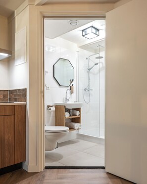 Un bagno moderno con doccia, WC e lavandino.