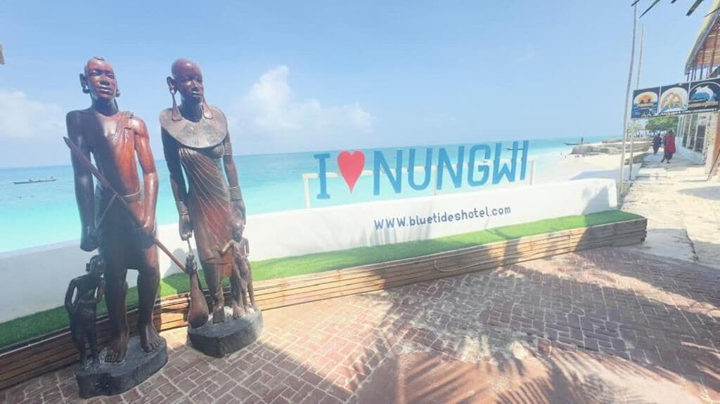 A beachside sign with 'I ♥ NUNGWI' and a website address.