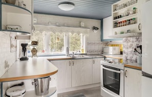 A kitchen with a microwave, oven, and various kitchen appliances. - 3 bedroom beautiful home in Ljungbyhed (Ljungbyhed)