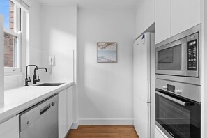 Een moderne keuken met witte kastjes, een Bosch vaatwasser, een Bosch koelkast en een Bosch oven.