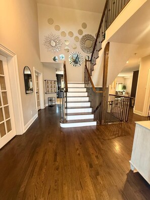 A staircase with a wooden finish and metal railings, leading to a second-floor landing.