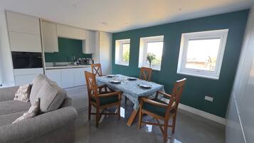 A modern kitchen with white cabinets and a dining area with a table set for four.