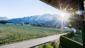 Eine Straße führt zu einem Berggebiet mit blauem Himmel und Sonnenschein.