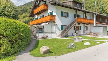 Eine zweistöckige Chalet mit Holzbalkon, Steinstufen und Bergblick.