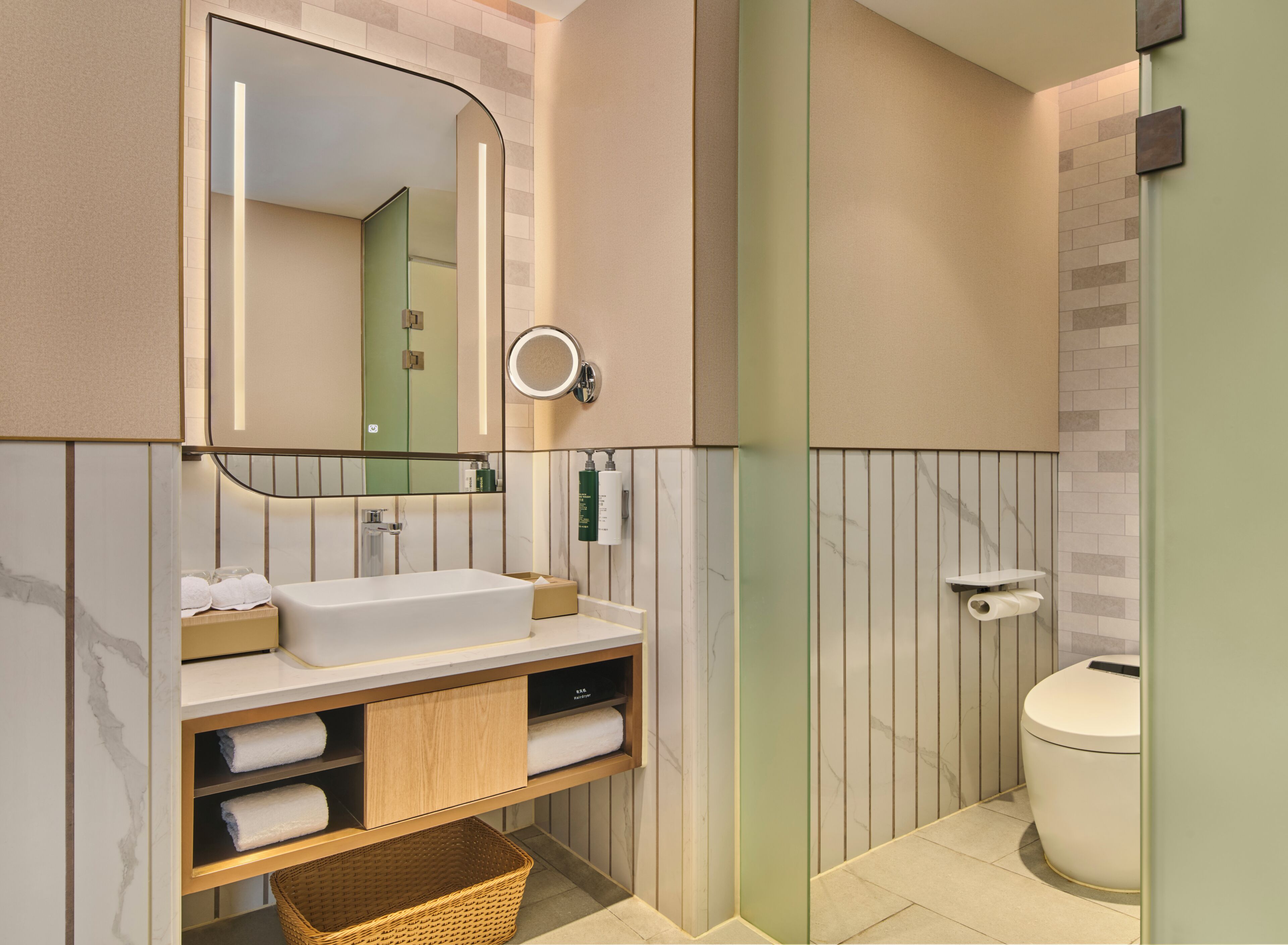 Un bany modern amb un mirall gran, un lavabo blanc i un vàter.