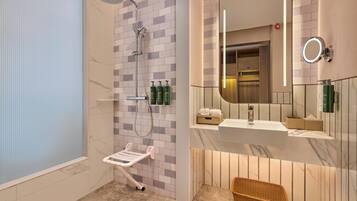 A modern bathroom with a shower, a vanity with a mirror, and a wicker basket.
