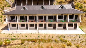 Een gebouw met twee verdiepingen, een balkon op de begane grond en een plat dak.