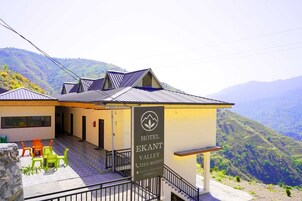 Hotel llamado 'Hotel Ekant Valley' con vista a la montaña.
