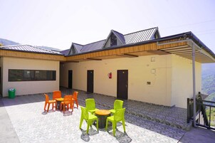 Un edificio con un patio cubierto, mobiliario exterior y vistas al paisaje.