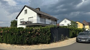A modern two-story house with a balcony, a black fence, and a parked car. - View of Karlstadt Castle (Karlstadt)