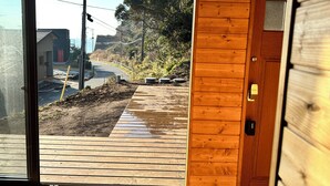 A wooden deck leading to a house with a visible road and power lines in the background. - Log Cabin with Ocean Views | Bonfire in a Private Satoyama Forest (富津市)