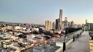 Eine Stadtansicht mit Wolkenkratzern, einem Fluss und einem Fußgängerweg.