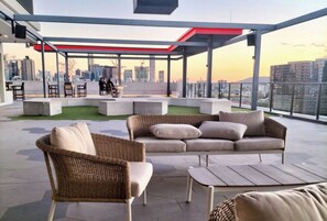 A rooftop terrace with outdoor seating, a city view, and a modern architectural design. - Fortitude Valley Pool Sauna & Gym (Brisbane)