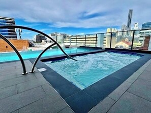 A rooftop pool with a city view, surrounded by a glass railing. - Fortitude Valley Pool Sauna & Gym (Brisbane)