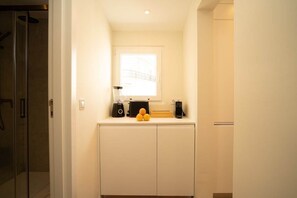 A bathroom with a shower, a sink with a mirror, and a window providing natural light. - Traditional Lisbon Building near Chiado and Santos (Lisbon)