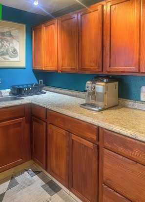 A kitchen with wooden cabinets, a granite countertop, and a toaster. - Hale Akala - Shared Home & Suite (Kailua-Kona)