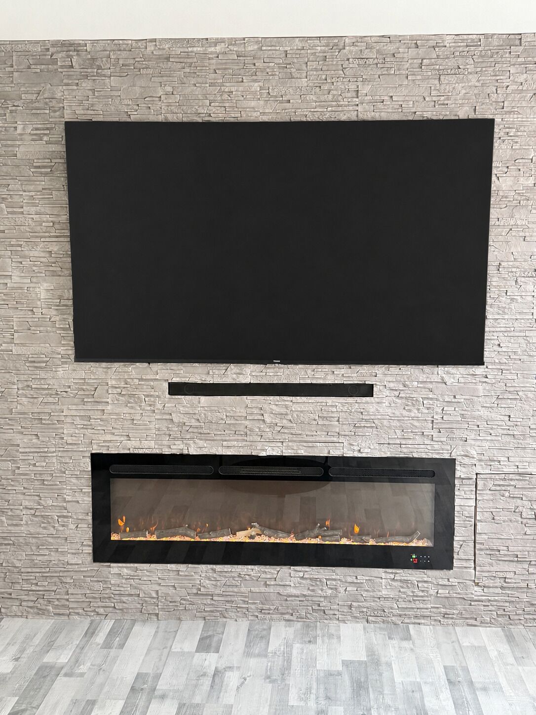 Una chimenea moderna con un televisor de pantalla plana montado encima.