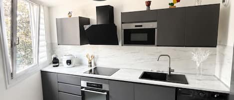 A modern kitchen with a built-in oven, a dishwasher, and a washing machine.