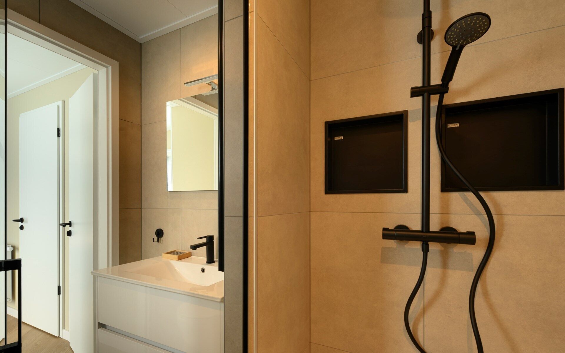 Une salle de bain moderne avec une douche, un lavabo et un miroir.