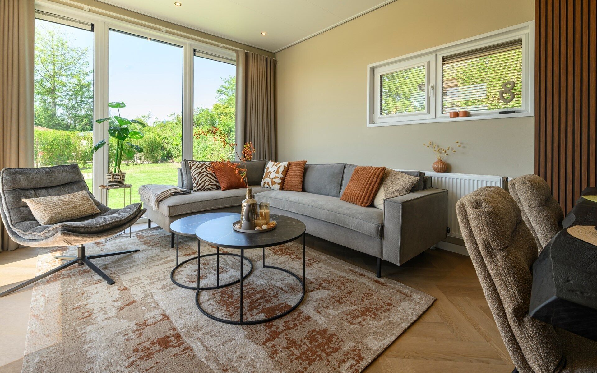 A living room with a grey sofa, a round coffee table, and a patterned rug.