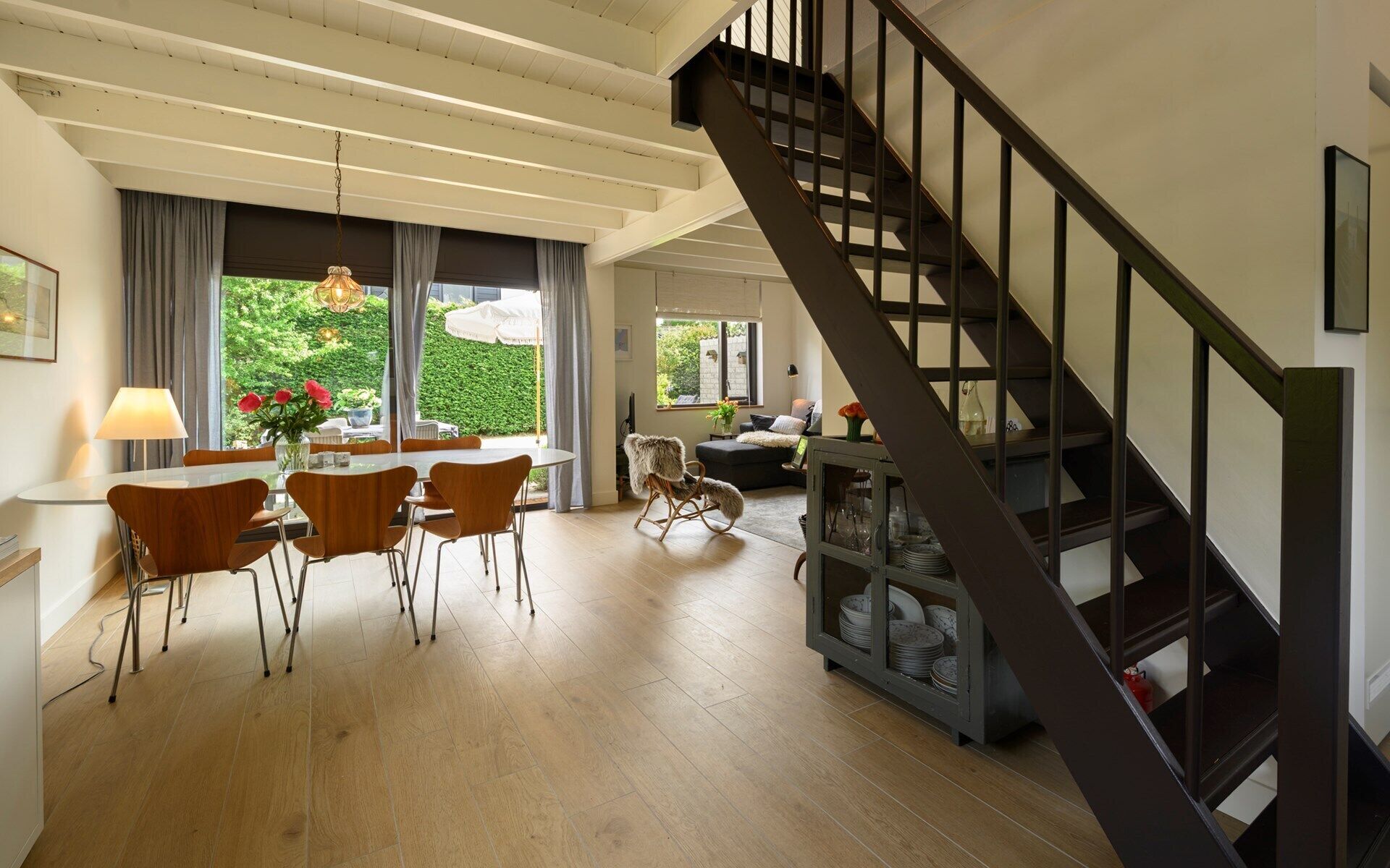 Un vaste espace de vie comprenant une table à manger, des chaises et un escalier.