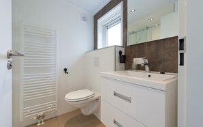A modern bathroom with a toilet, a sink, and a mirror. - Hoeve Lodge "De Meidoorn" (Burgh-Haamstede)