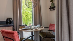 A cozy dining area with a round table, chairs, and a coffee maker. - Hoeve Lodge "De Meidoorn" (Burgh-Haamstede)