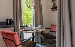 A cozy dining area with a round table, chairs, and a coffee maker. - Hoeve Lodge "De Meidoorn" (Burgh-Haamstede)
