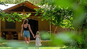 A wooden cabin with a porch and a small deck. - Luxury Safari Tent Renesse (Renesse)