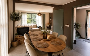 Un comedor con una mesa redonda de madera, individuales tejidos y sillas.