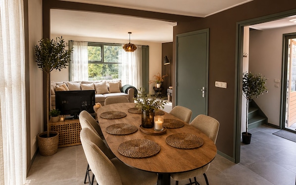 A dining area with a round wooden table, woven placemats, and chairs.
