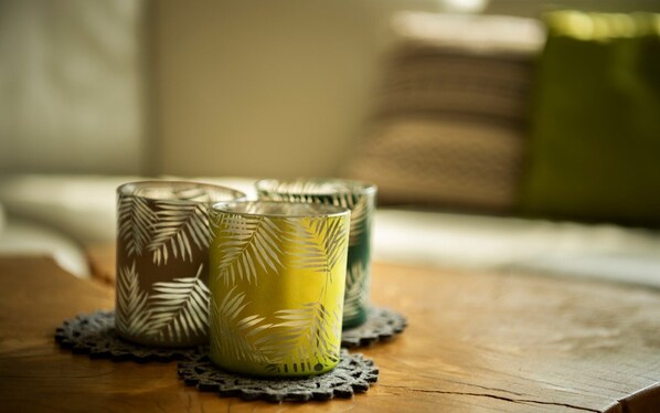 Three candle holders with leaf patterns on a wooden surface.