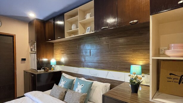 A bedroom with a bed, bedside tables, a nightstand, a dresser, and built-in shelving. - Rural Stay Baan Mea Pen  Nature Retreat  (Chiang Rai)