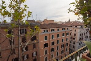 A multi-story building with balconies and a view of the surrounding urban area. - GuestHost - Classy Apartment in Termini with Terrace (Rome)