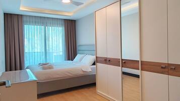 A modern bedroom with a bed, a wardrobe, and a ceiling fan.