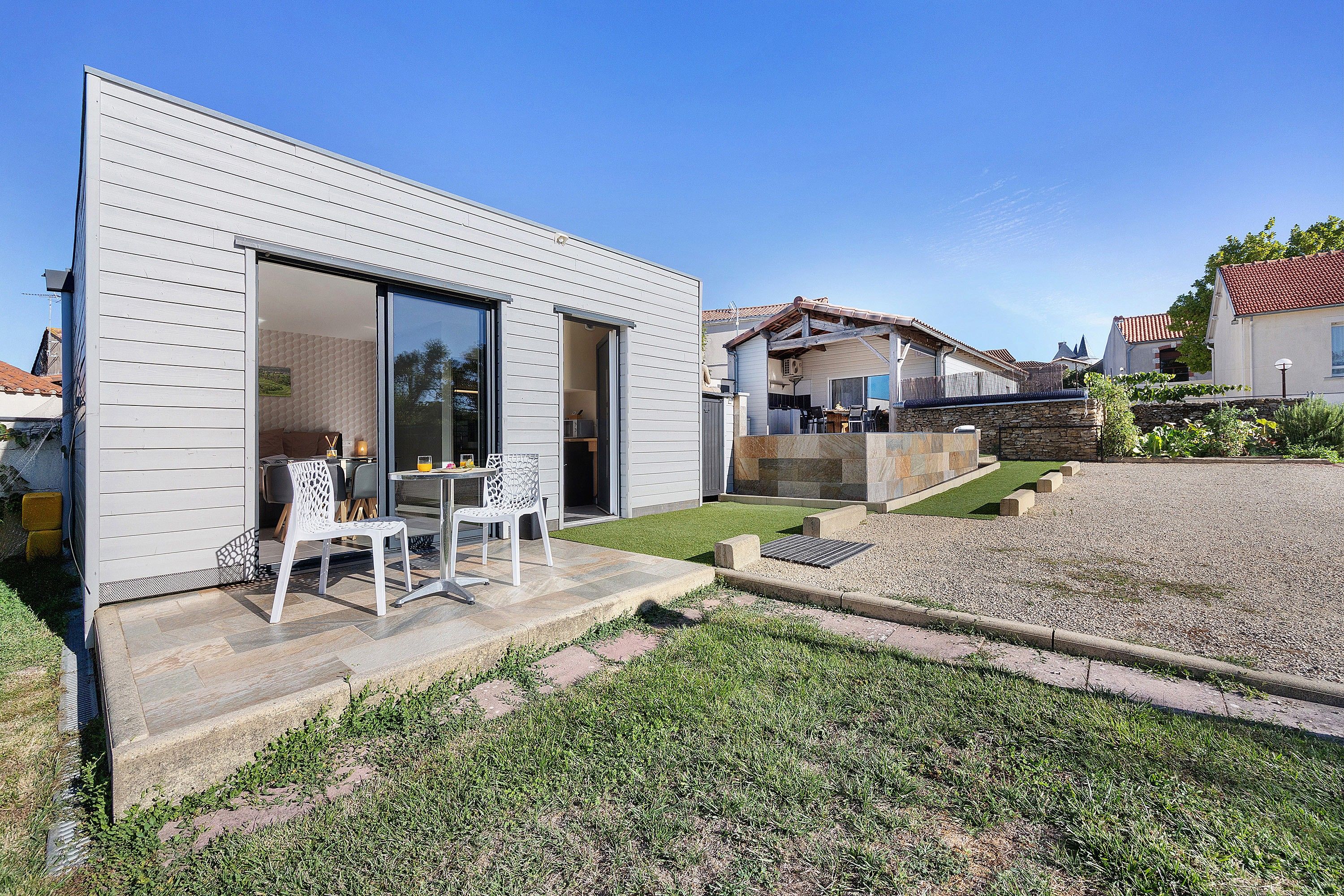Una casa moderna con un patio que tiene una mesa y sillas.