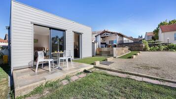 Una casa moderna con un patio que tiene una mesa y sillas.