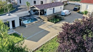 Una proprietà residenziale con piscina, zona relax all'aperto coperta e posto auto.