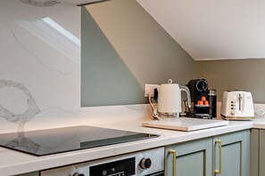 A kitchen with a marble backsplash, a coffee machine, a toaster, and a kettle on the countertop. - Host & Stay | The Georgian Quarter @ Catharine V (Liverpool)